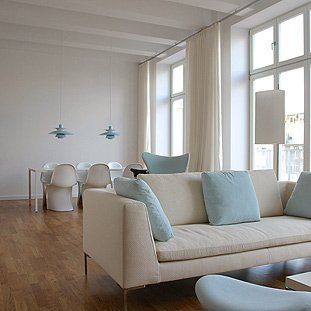 Ein Wohnzimmer mit einer weißen Couch und blauen Kissen