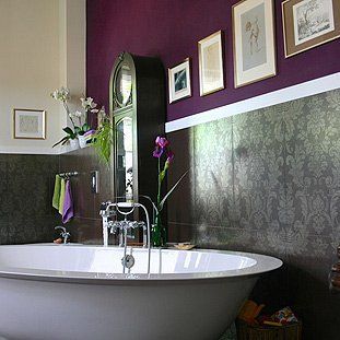 Eine Badewanne in einem Badezimmer mit violetten Wänden