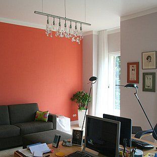 Ein Wohnzimmer mit einer Couch und einem Schreibtisch mit einem Computer darauf