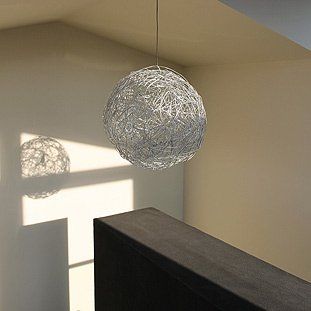 In einem Raum hängt eine Pendelleuchte von der Decke.