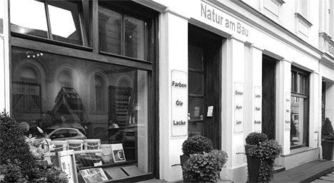 Ein Schwarzweißfoto eines Gebäudes mit einem Schild mit der Aufschrift „Natur am Bau“