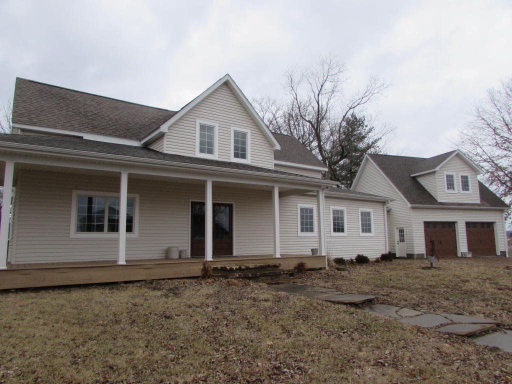 A large white house with a porch and a garage