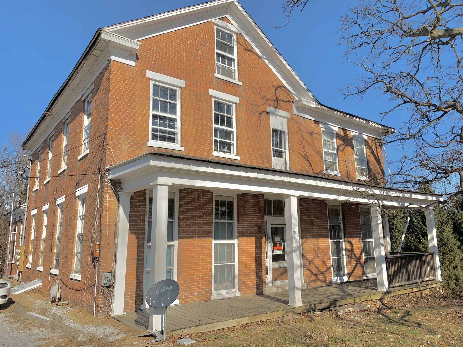 A large red brick building with a white porch