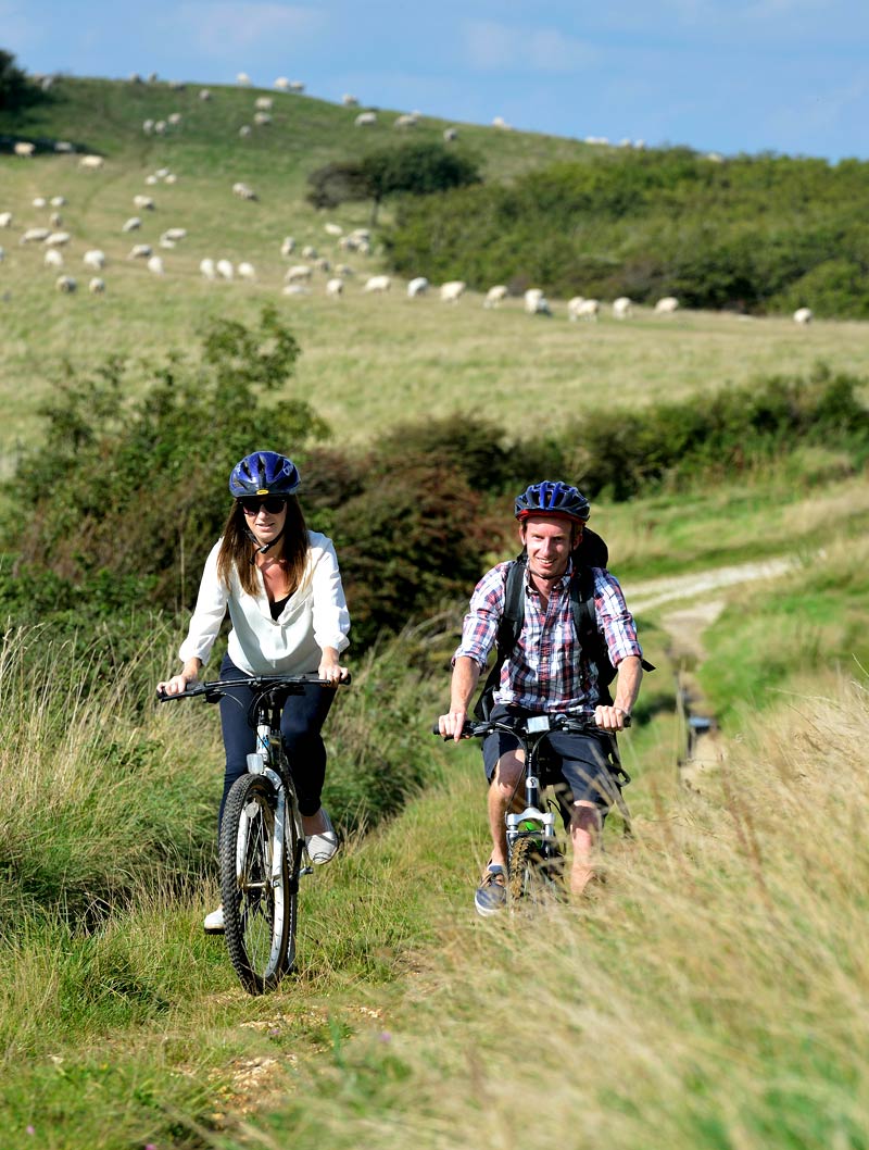 A man and woman cycling the south downs way