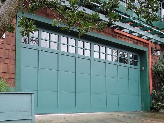 A large green garage door with a lot of windows