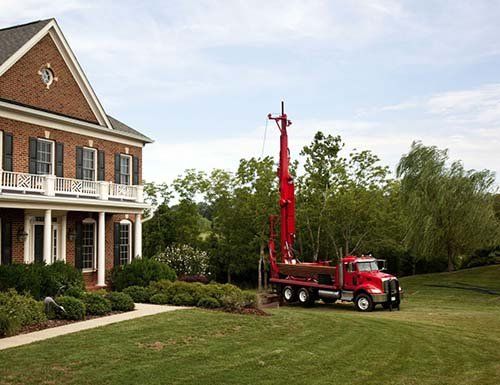 Well drilling equipment next to house in Benedict, NE