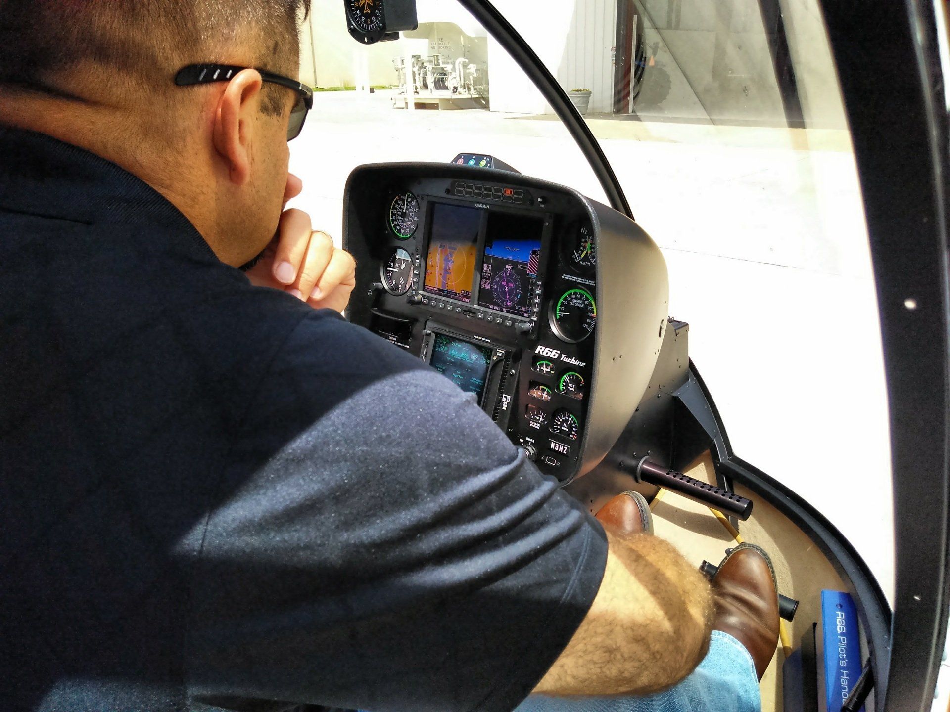 A man is sitting in the cockpit of a helicopter
