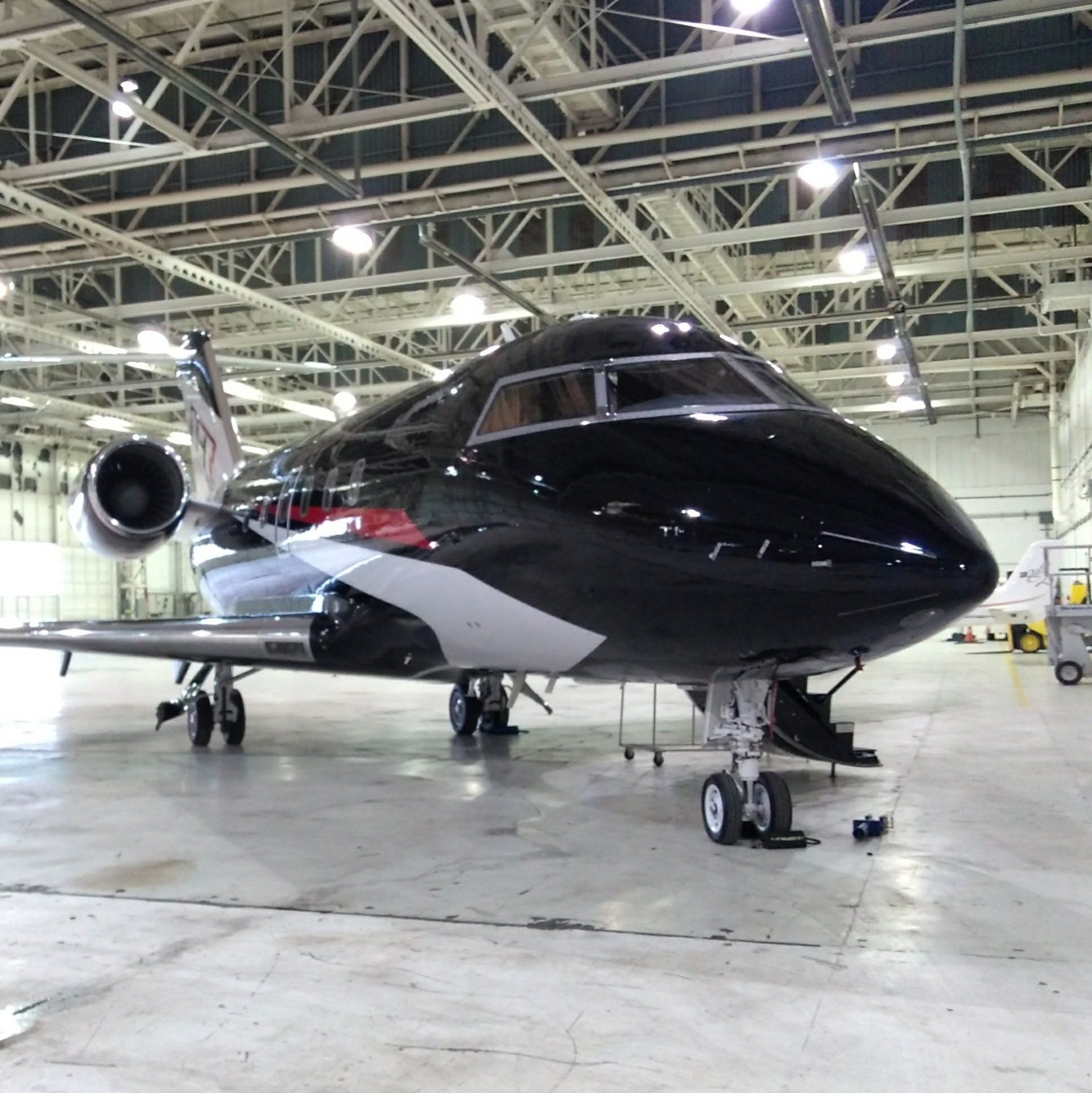 A black and white airplane is parked in a hangar