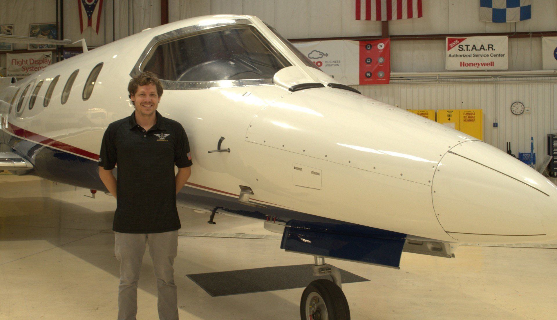 A man stands in front of a plane with the letter l on it