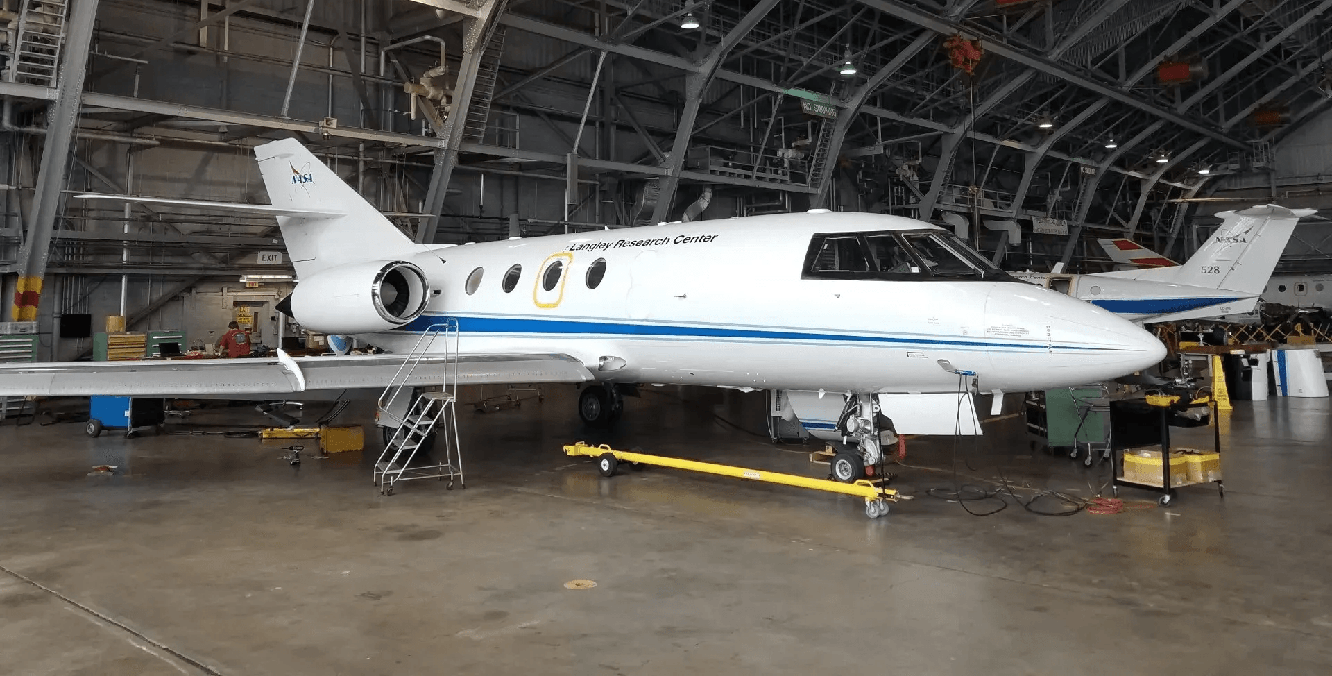 A white and blue airplane is parked in a hangar