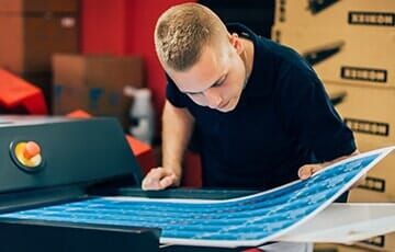 Man checking print quality — Design in Allentown, PA Man checking print quality — Design in Allentown, PA