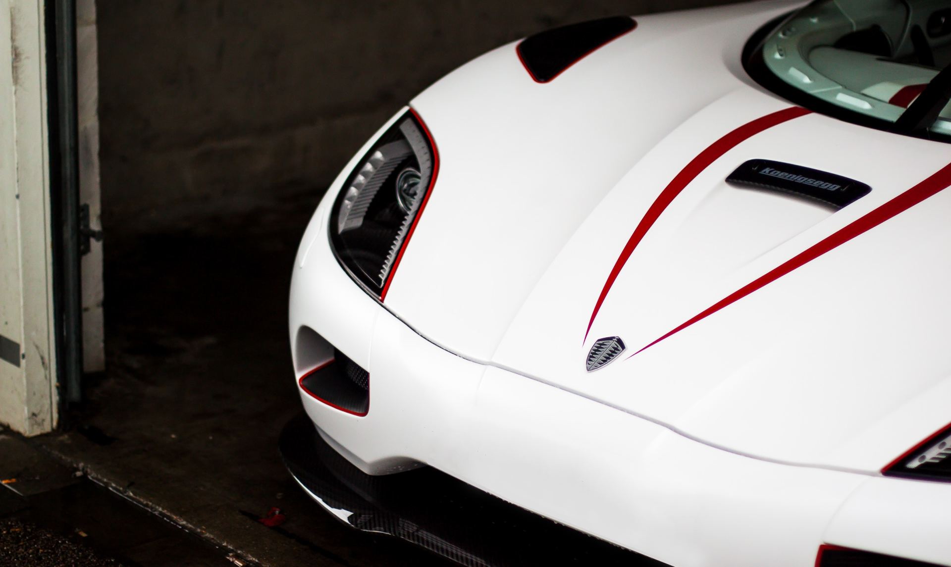 A white sports car with red stripes on the hood