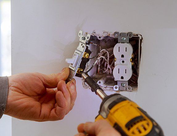 Electrician Installing a Power Switch — Clairsville, OH — Bryan Electric Inc.