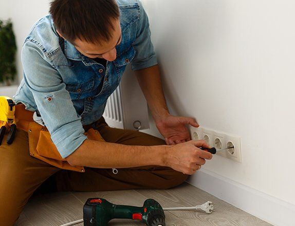 Electrician Checking Socket Voltage with Digital Multimeter — Clairsville, OH — Bryan Electric Inc.
