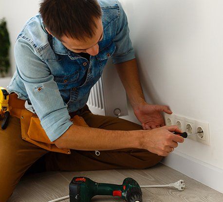Electrician Checking Socket Voltage with Digital Multimeter — Clairsville, OH — Bryan Electric Inc.