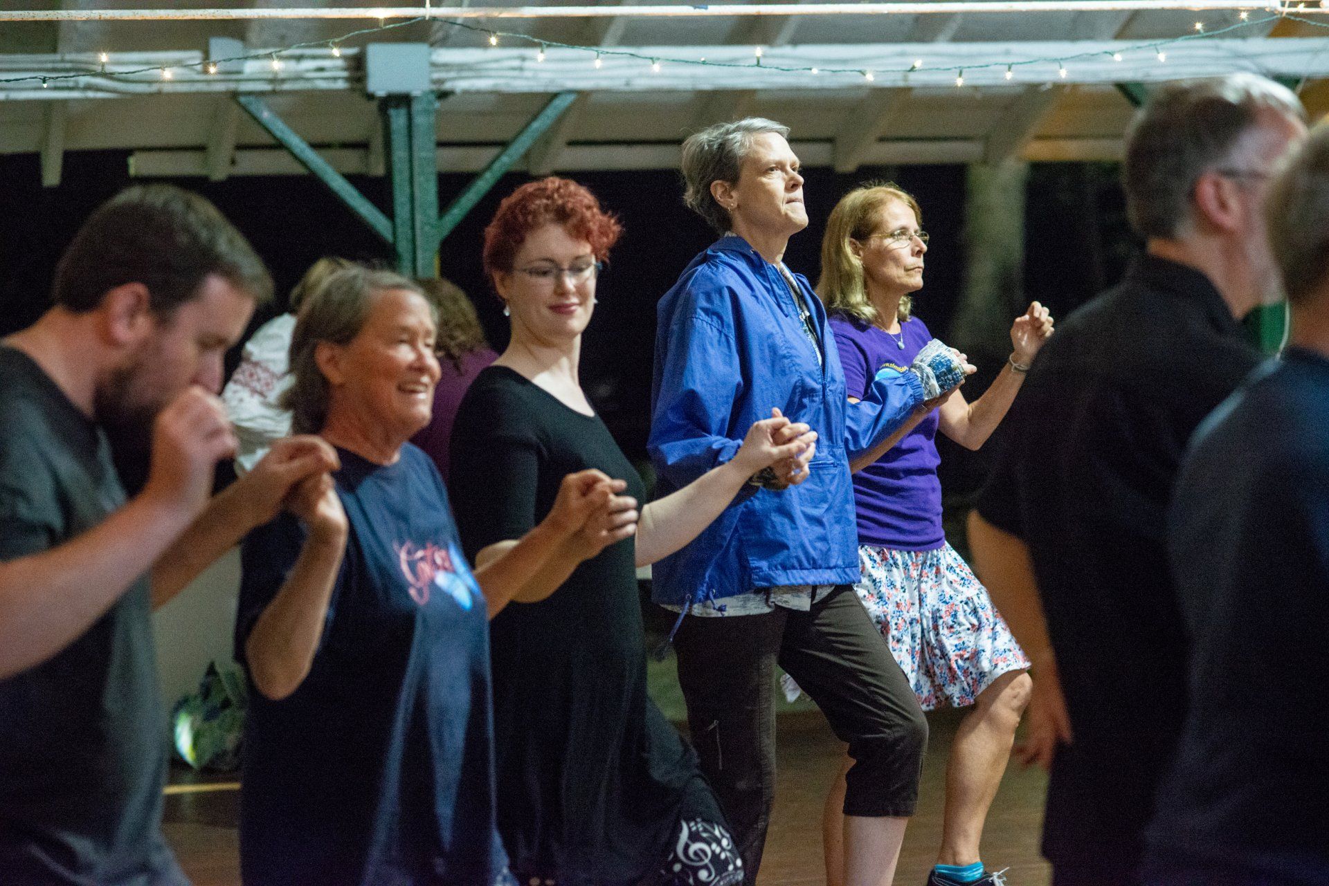 A group of people are dancing together in a room.