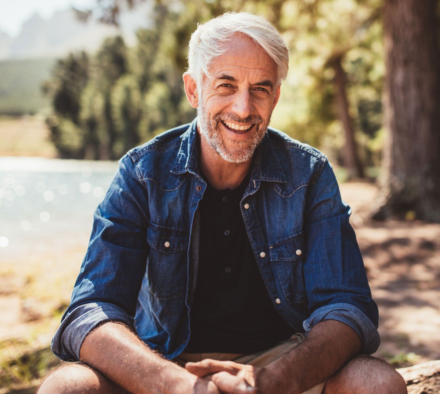 Mature Man Sitting Near a Lake — Warren, Ohio — Lordstown Dental Clinic Mature Man Sitting Near a Lake — Warren, Ohio — Lordstown Dental Clinic