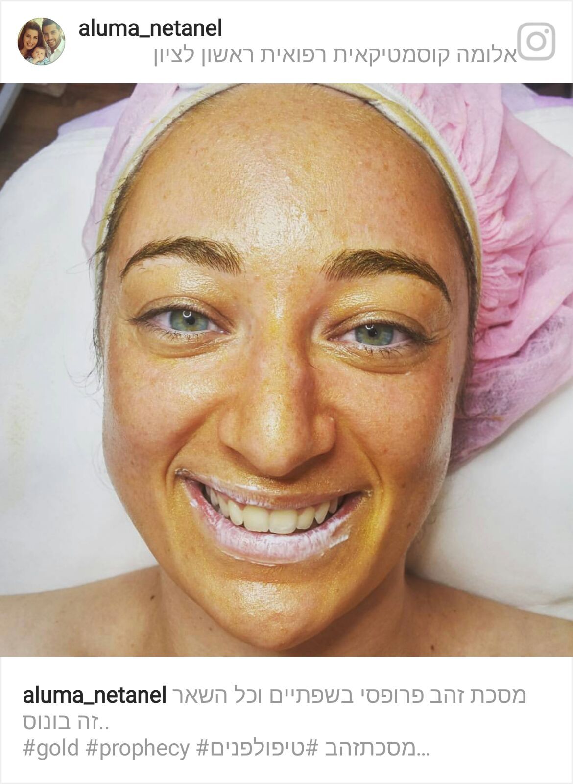 Smiling person with gold facial mask and hair wrapped in a pink towel, lying down on a spa bed