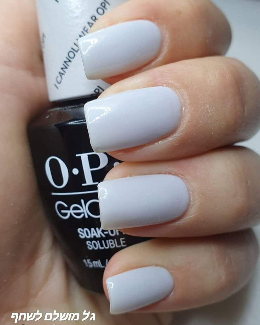 Hand with pale lavender nails holding OPI nail polish bottle