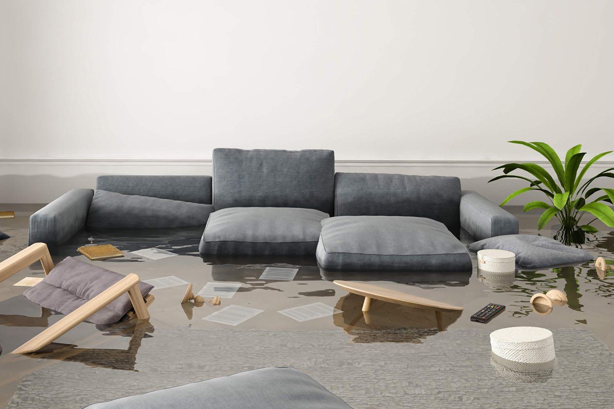 A living room with a couch and chairs covered in water.