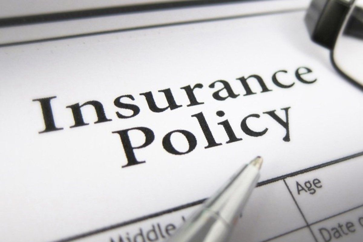 An insurance policy with a pen on top of it