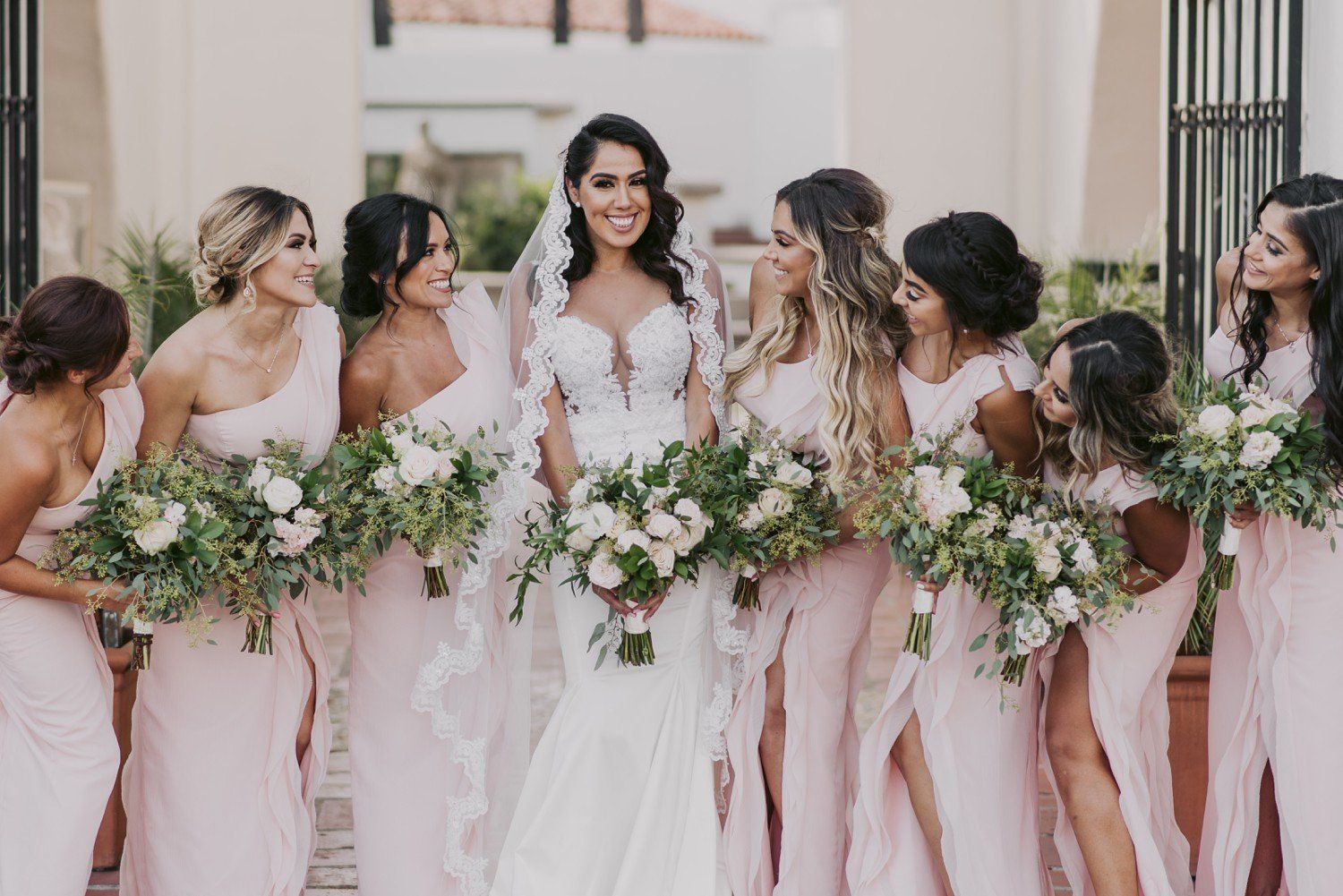 A bride and her bridesmaids are posing for a picture together.