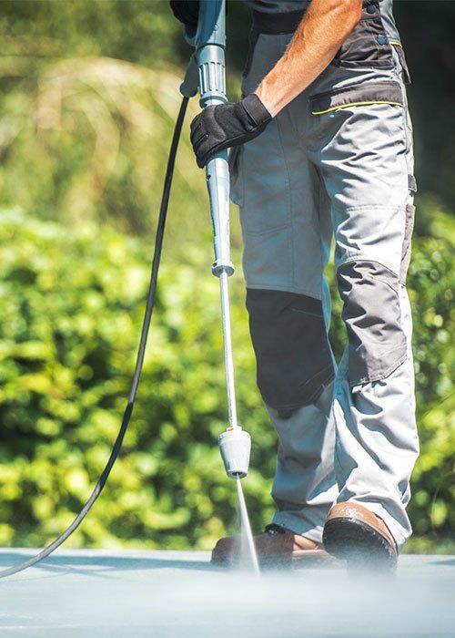 A Worker Using A Pressure Cleaner — Tropical Cleaning Services in Innisfail, QLD