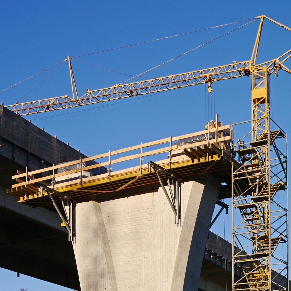A bridge under construction with a crane in the foreground