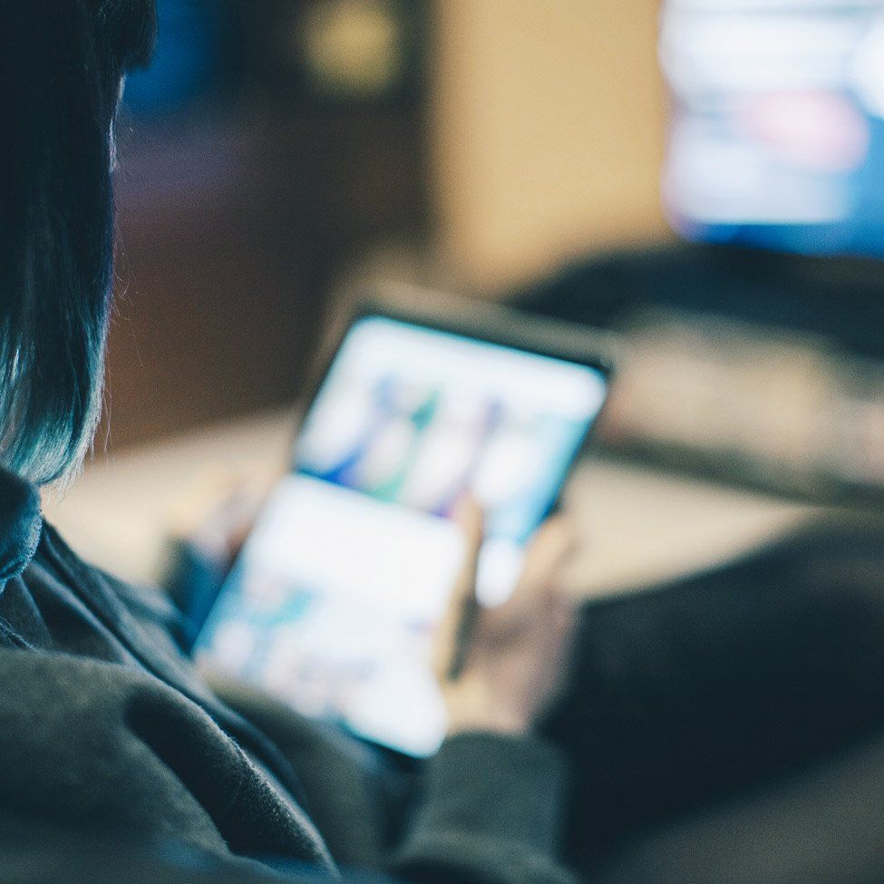 A woman is holding a cell phone in her hand.