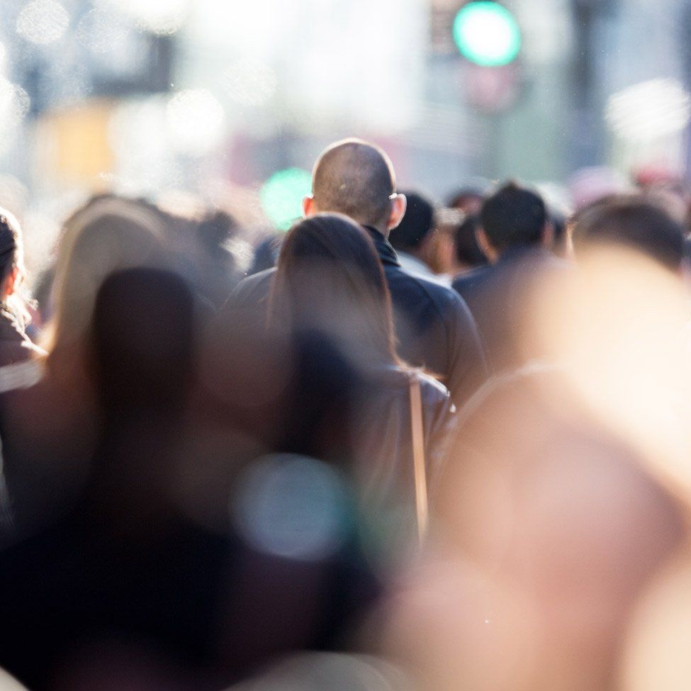 A crowd of people are walking down a street.