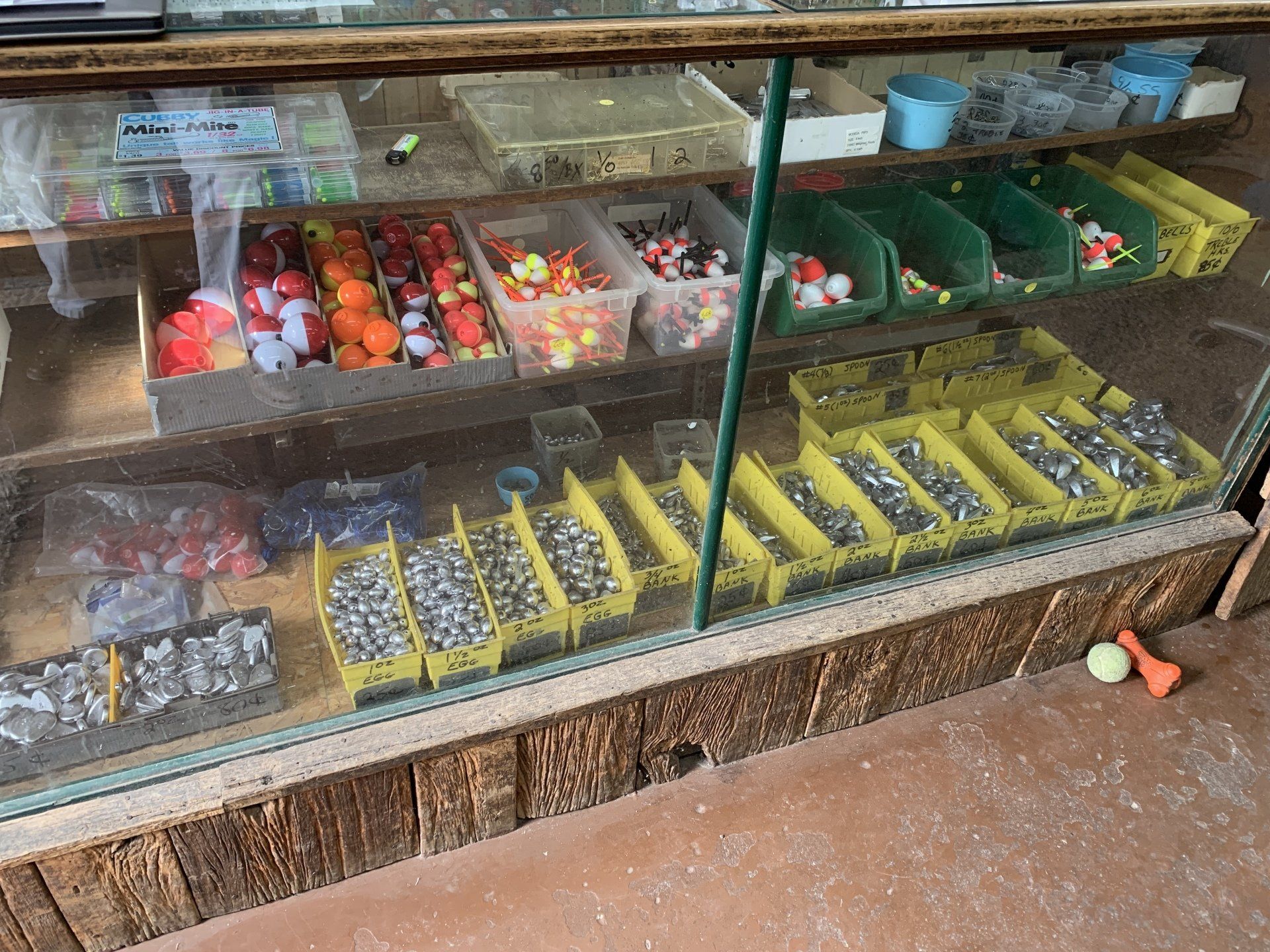 Fishing tackle display case with colorful floats, weights, and accessories.