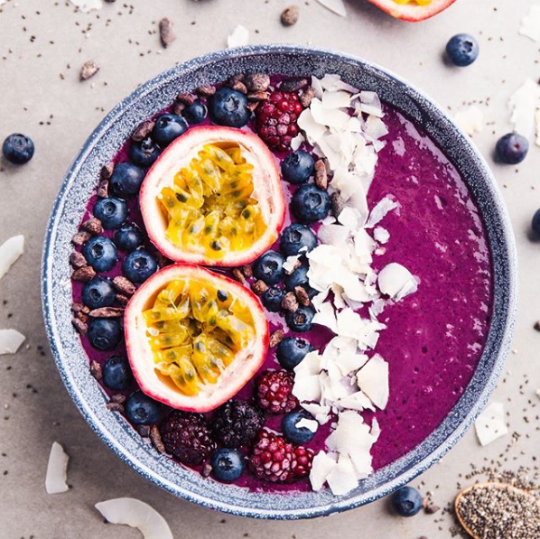 Eine Schüssel lila Smoothie mit Blaubeeren und Passionsfrucht