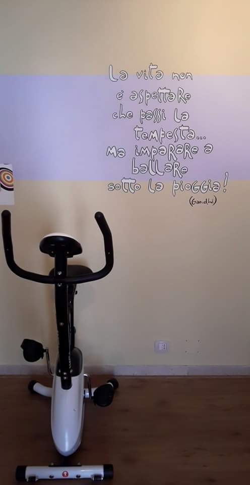 Cyclette in una stanza con una citazione motivazionale sulla parete.