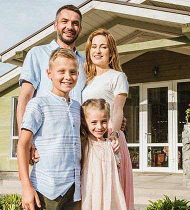 Happy Family Outside House — Greenwood, SC — Mabry Sanders Insurance Agency Happy Family Outside House — Greenwood, SC — Mabry Sanders Insurance Agency