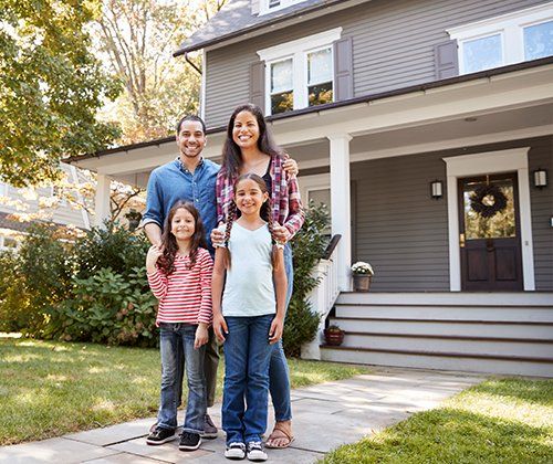 Happy Family Outside House — Greenwood, SC — Mabry Sanders Insurance Agency Happy Family Outside House — Greenwood, SC — Mabry Sanders Insurance Agency