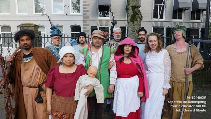 Een groep mensen in kostuums poseert buiten voor een gebouw.