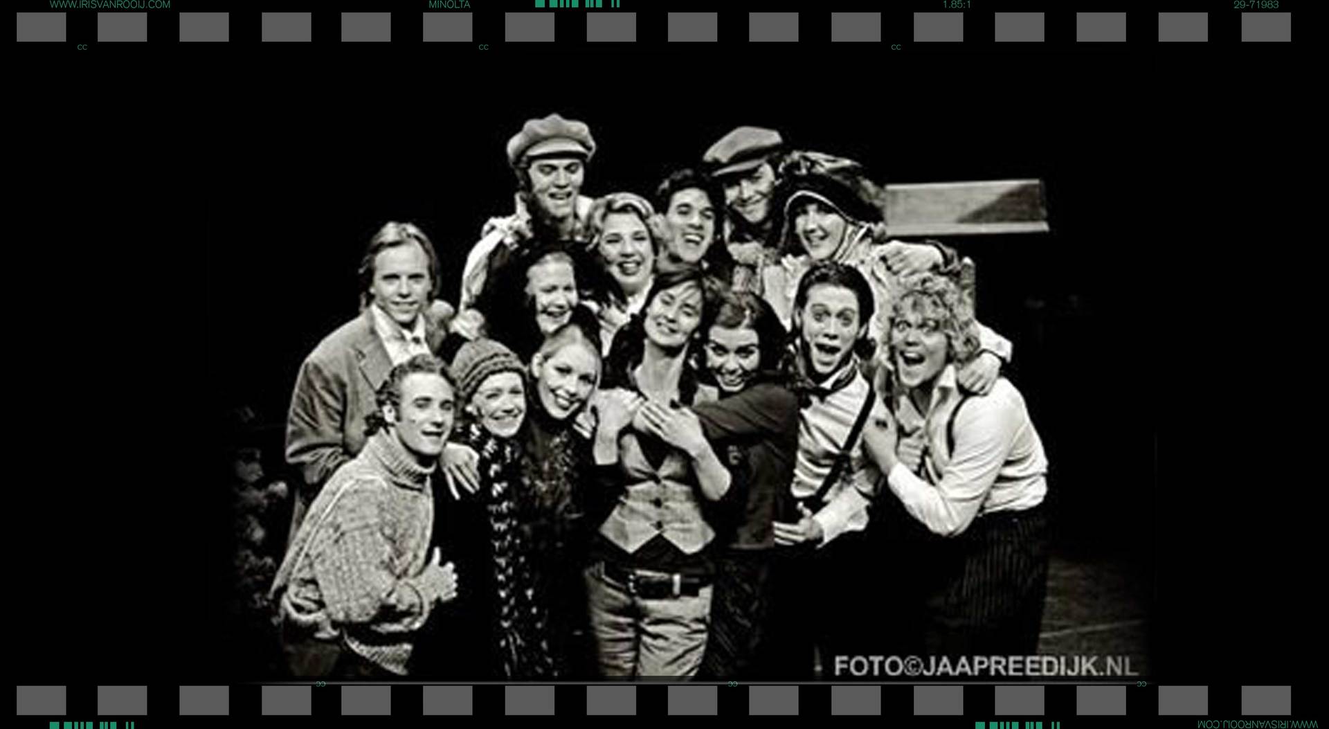 Een groep mensen die samen poseren, waarschijnlijk een cast, zwart-witfoto.