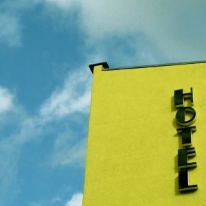 Ansicht auf gelbe Hotelfassade mit schwarzen Lettern 