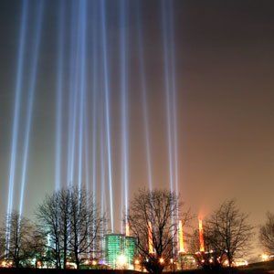 Eine Stadt bei Nacht, in der viele Lichter aus dem Himmel kommen.