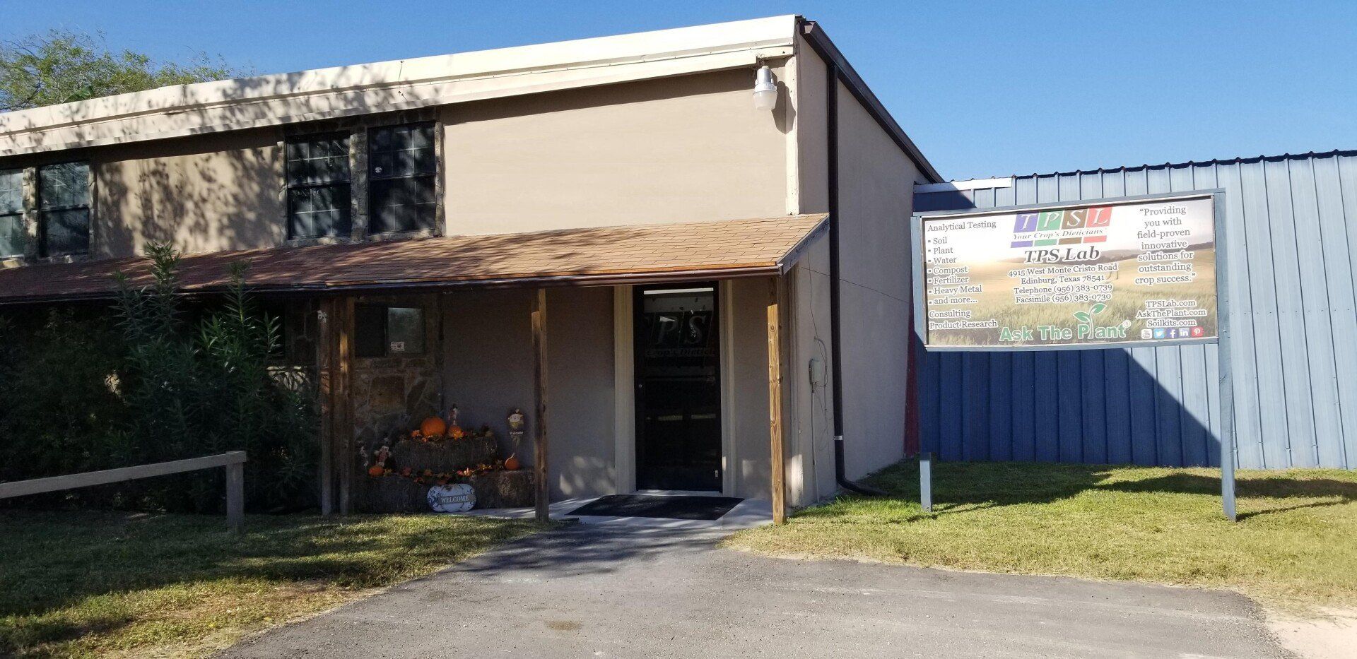 A building with a porch and a sign on the side of it.