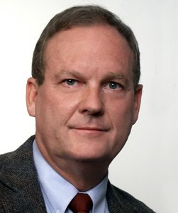 A man in a suit and tie is smiling for the camera