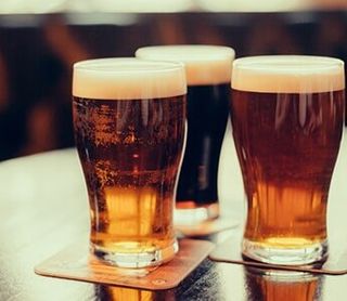 Glasses of Light and Dark Beer on a Pub Background — Liquor Store in Wilmington, DE Glasses of Light and Dark Beer on a Pub Background — Liquor Store in Wilmington, DE