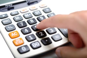A person is pressing a button on a calculator with their finger.