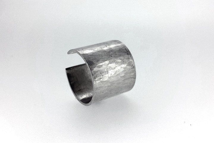 Open, adjustable sterling silver ring with hammered, faceted texture