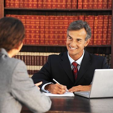 Please show a lawyer talking to a person over a table Please show a lawyer talking to a person over a table