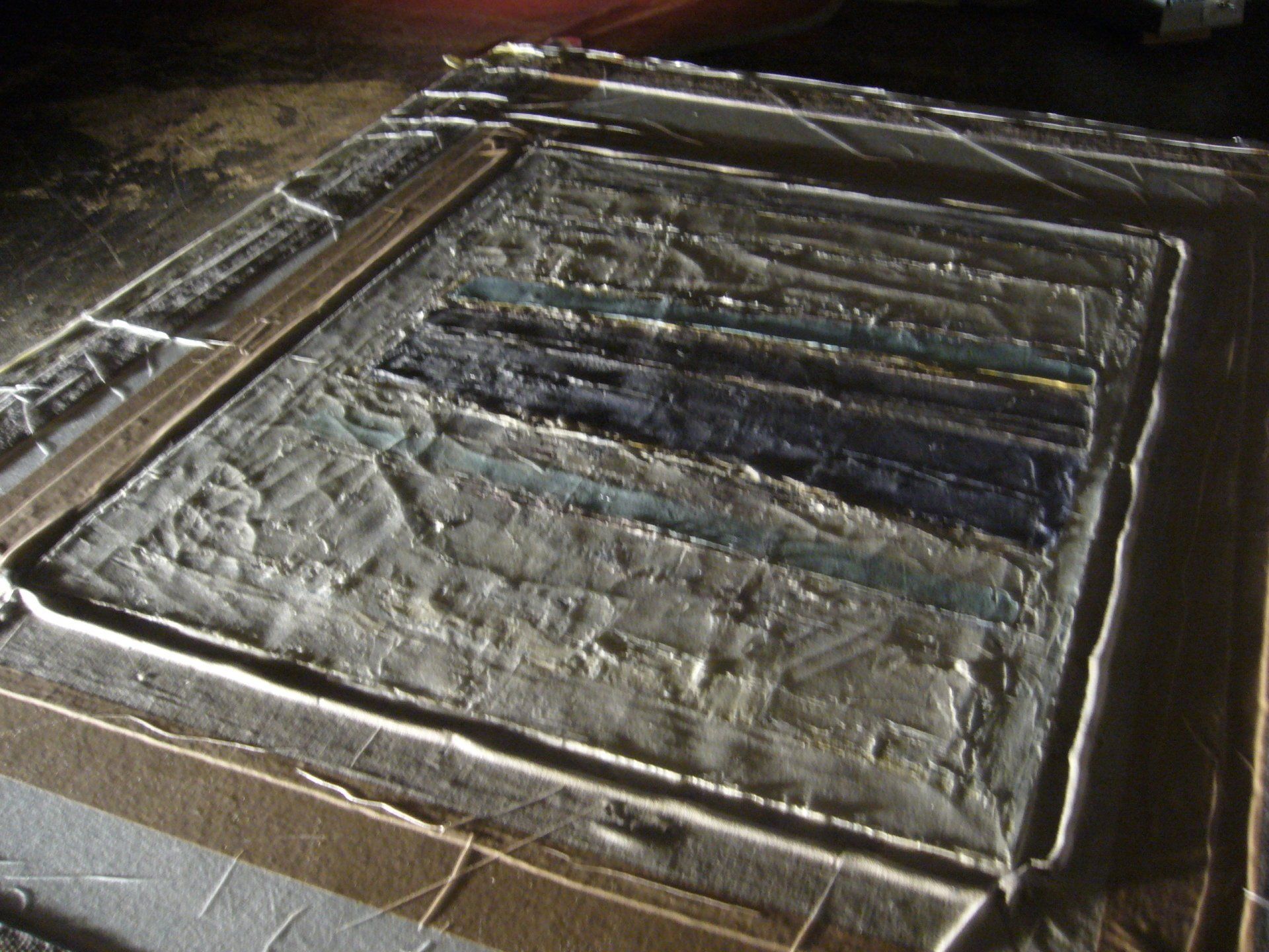 Before surface treatment commences inside vacuum bag under raking light