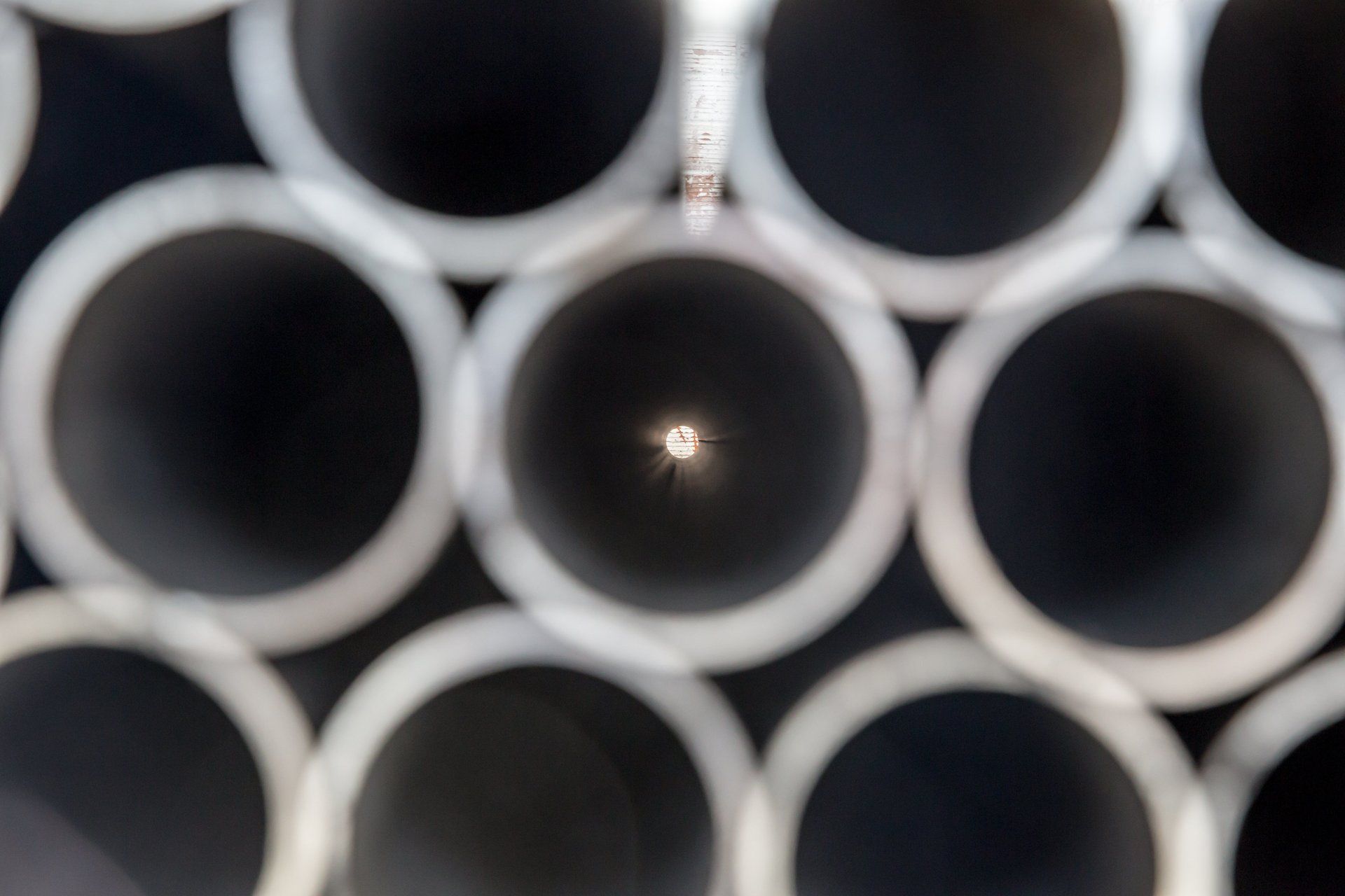Tubi neri impilati con centro luminoso evidenziato, in una vista dall'alto.