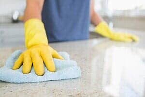 Person weeping the table — janitorial in Greeley, CO Person weeping the table — janitorial in Greeley, CO