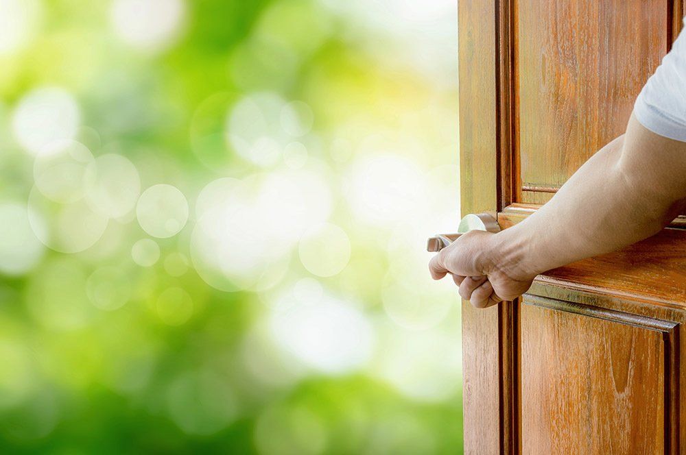 Man Opening the Door — Denver, CO — Adams Lumber Company One of the home remodeling interior doors produced by a company near Southglenn, CO