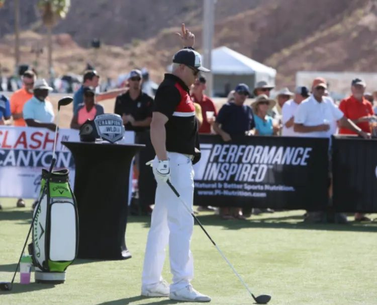 A man playing golf in front of a performance inspired sign